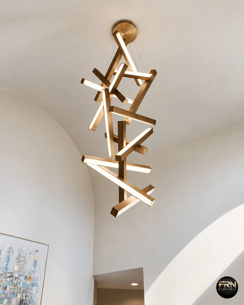 Sculptural gold pendant light in a double-height interior