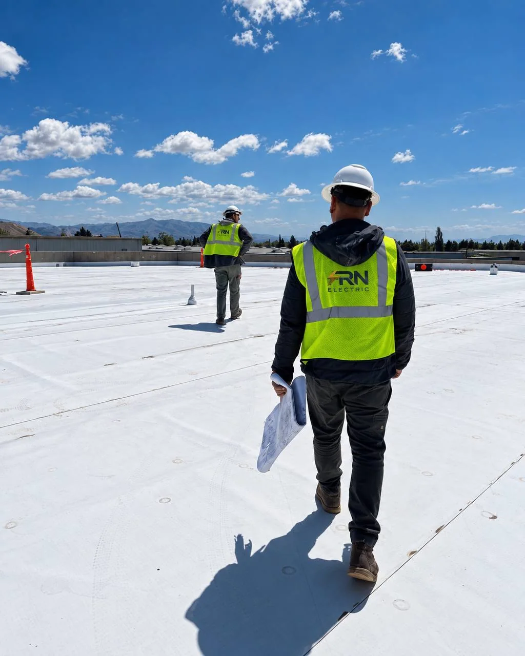 FRN Electric team members on a rooftop with project plans